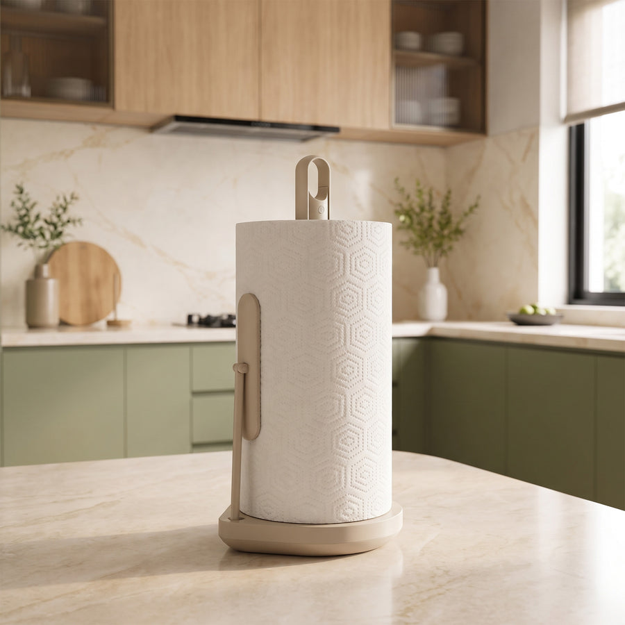 Simplehuman's Paper Towel Holder with Spray in Latte in a modern kitchen setting with marble countertops and light wooden and green cabinetry. 