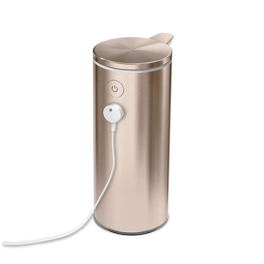 Detail view of Simplehuman 9 oz. Sensor Pump in Rose Gold, showing power button and magnetic charging cable attached, rechargeable.