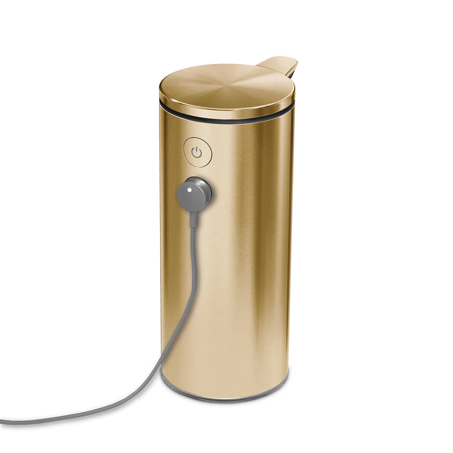 Detail view of Simplehuman 9 oz. Sensor Pump in Brushed Brass with magnetic charging cable attached, rechargeable.