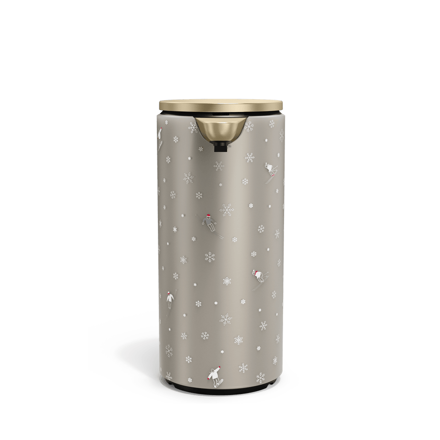 Front view of Simplehuman Matte Gold 14 oz. Sensor Pump with holiday sleeve. White, frosted sleeve with skiers and snowflakes. 