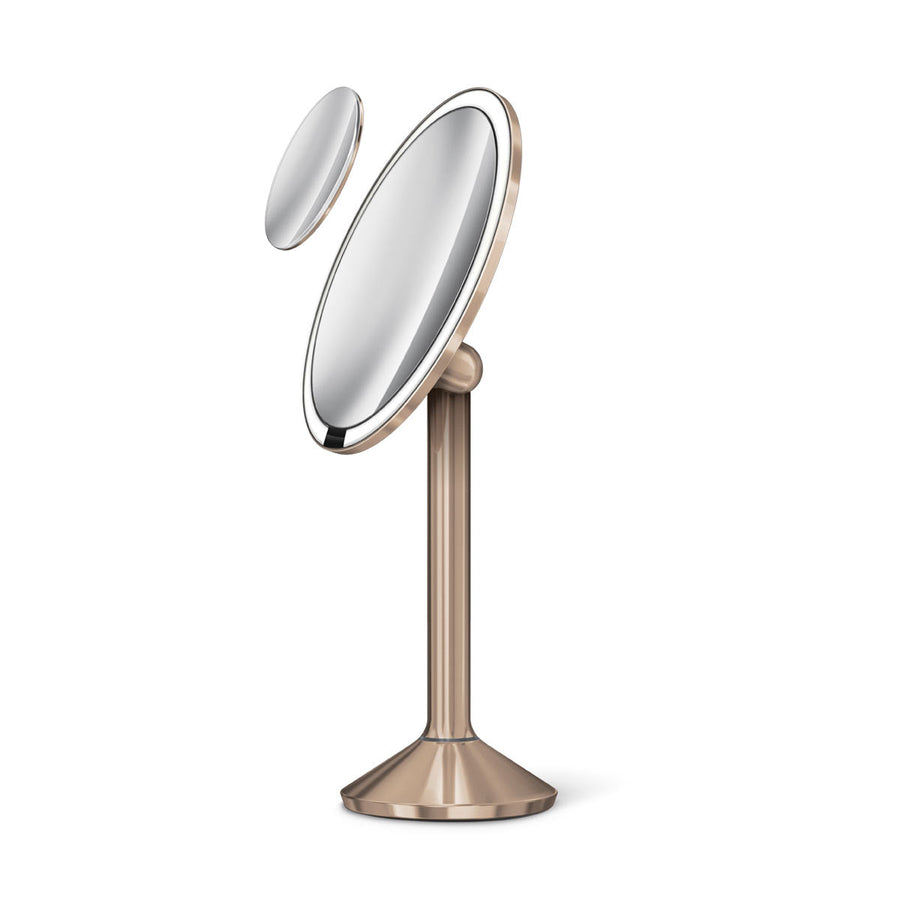 Angled studio view: Simplehuman Sensor Mirror Pro Round, Rose Gold, with detached magnetic zoom mirror and tru-lux lighting.