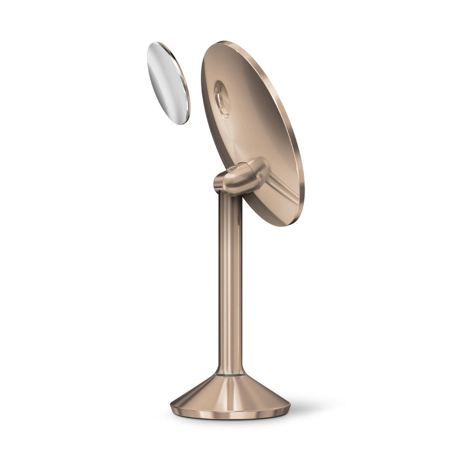 Side view of Simplehuman Sensor Mirror Pro Round, Rose Gold, showing the detached magnetic zoom mirror accessory.