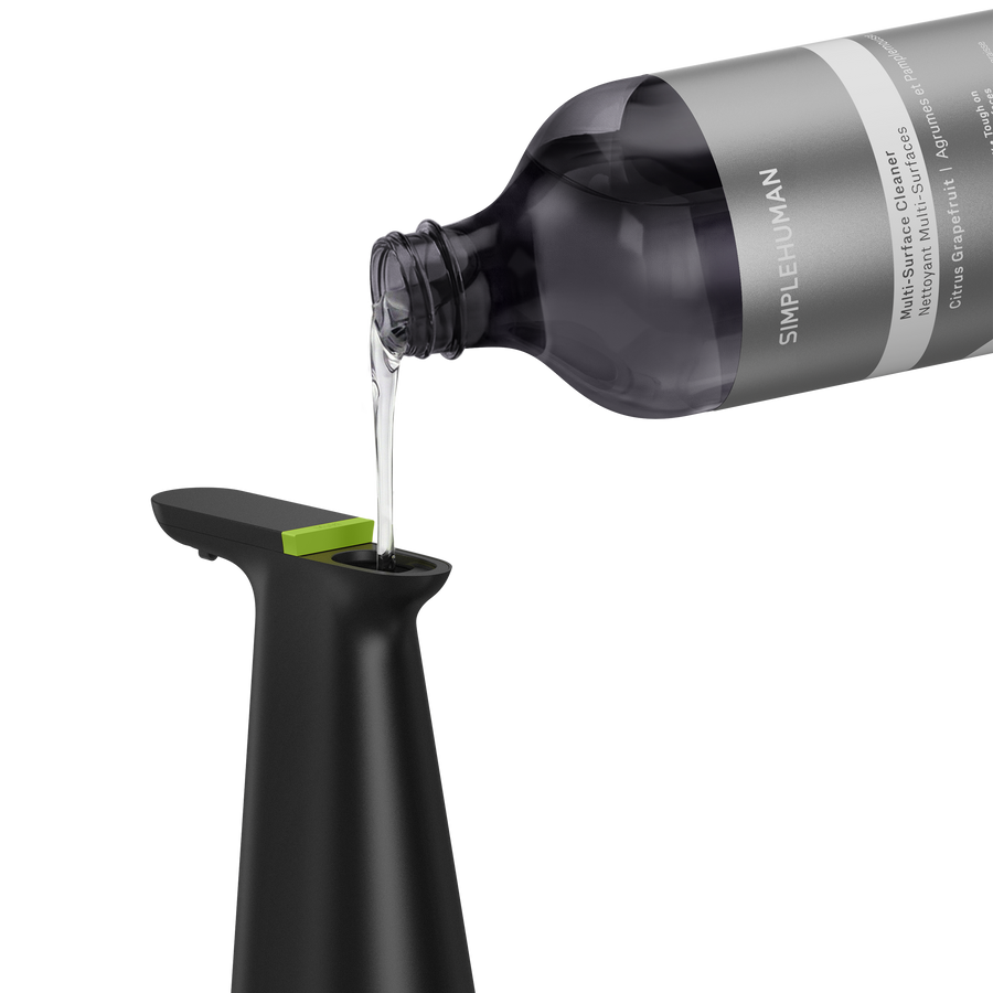 Simplehuman's Sensor Spray in Matte Black with Multi-Surface Cleaning Refill Bottle pouring into the spout. 