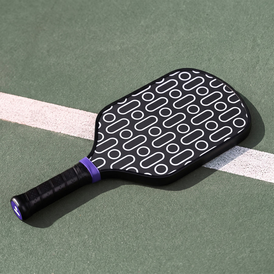 Simplehuman's Pickleball Paddle resting flat on a court. 