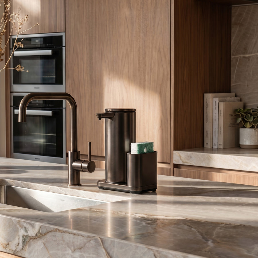 Simplehuman's 14 oz. Liquid Sensor Pump with Caddy in Oiled Bronze on a marble countertop in a rustic, kitchen setting.