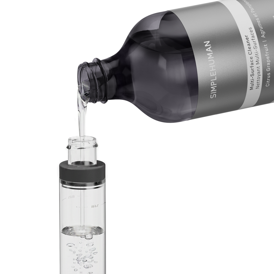 Simplehuman's Refill Bottle filling a Simplehuman Paper Towel Holder with Spray. 