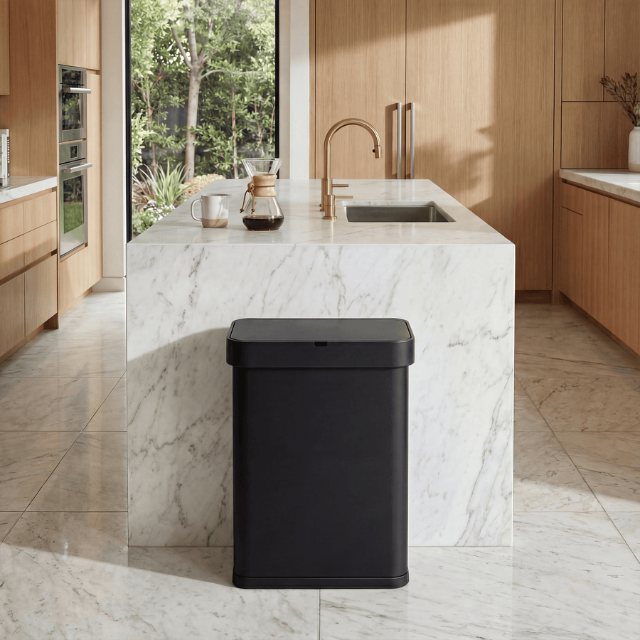 Simplehuman's Matte Black Sensor Can in Matte Black inside of a lived in Modern house with wood cabinets, marble counter top and coffee on top of the marble island.