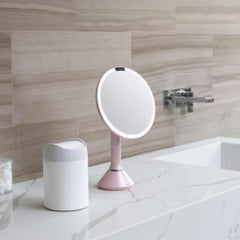 sensor mirror with touch-control brightness - pink finish - lifestyle on counter